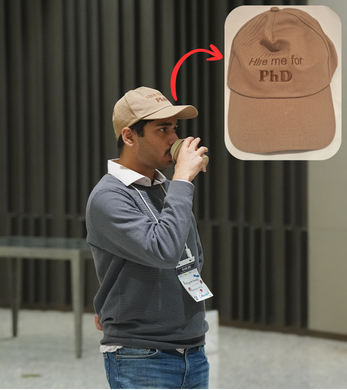 Me wearing a cap that says 'Hire me for PhD' at ASE 2025.
